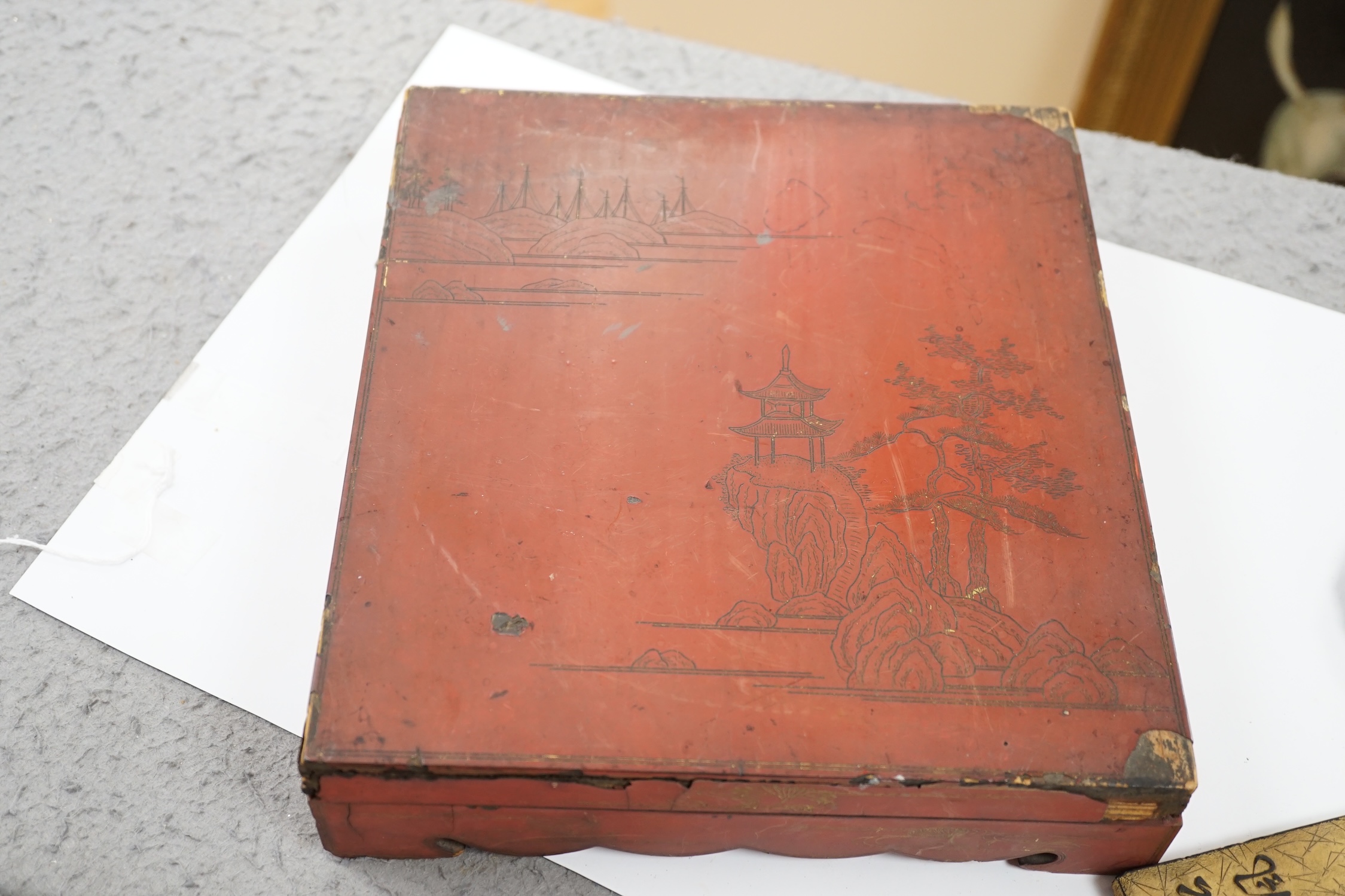 Literati interest: a Chinese red lacquer writing box, 26.5 x 24 x 6.5cm, with two inkstones, a brass paper cutter and ink cake. Condition - fair, some damage to edges and corners of the box